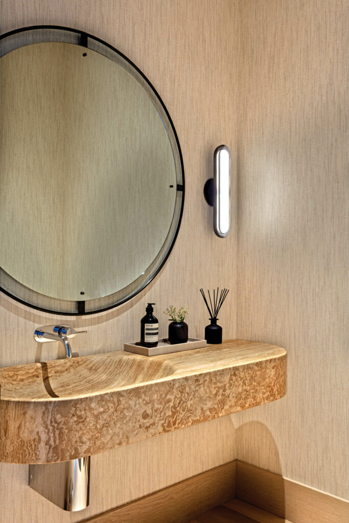 a powder room with a carved stone vanity