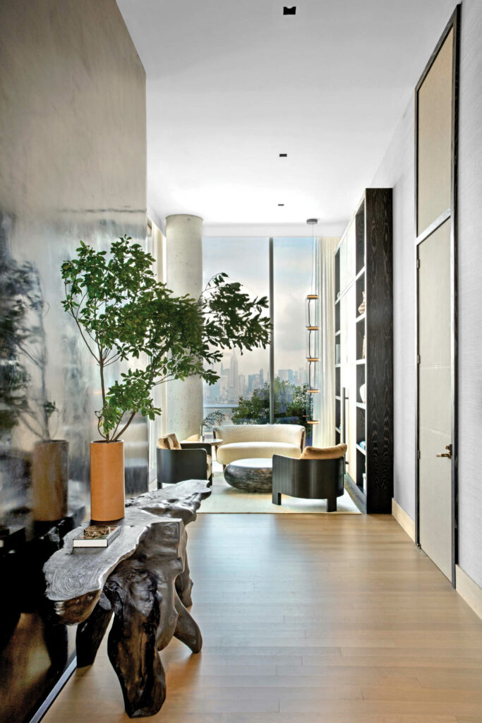 a teak console holds a planter in the entry way of an NYC penthouse apartment