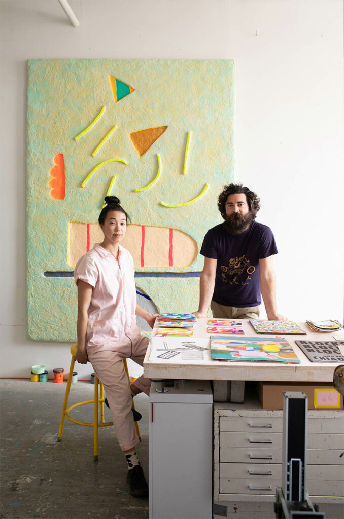 Terri Chiao and Adam Frezza stand by a table with their creations