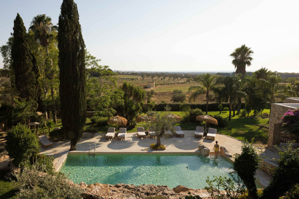 an outdoor pool at Tenuta Negroamaro, among lush Italian landscape