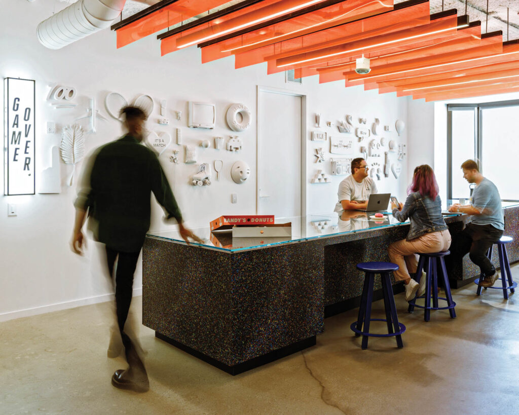 Employees gather around a coworking counter at the Tinder office in L.A.