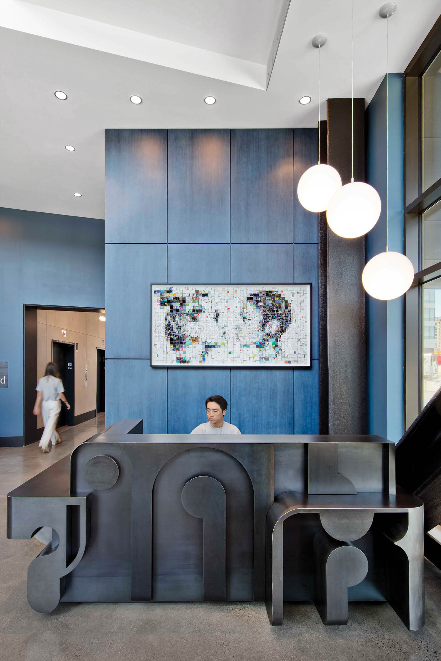 a black geometric reception desk and blue walls in a Boston apartment