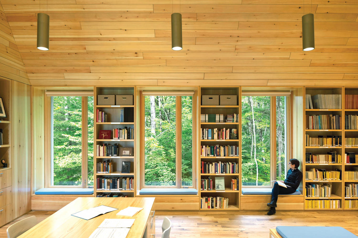 large windows and reading nooks overlook a tree-scape at a music hall