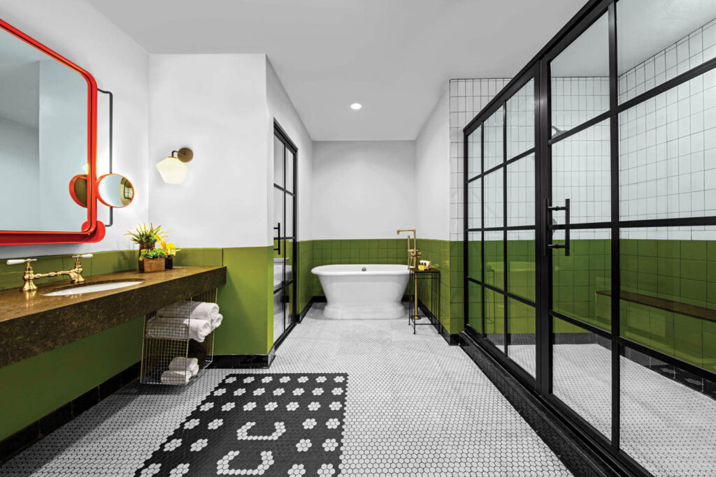 a junior suite bathroom with mirror and shower framed in painted steel