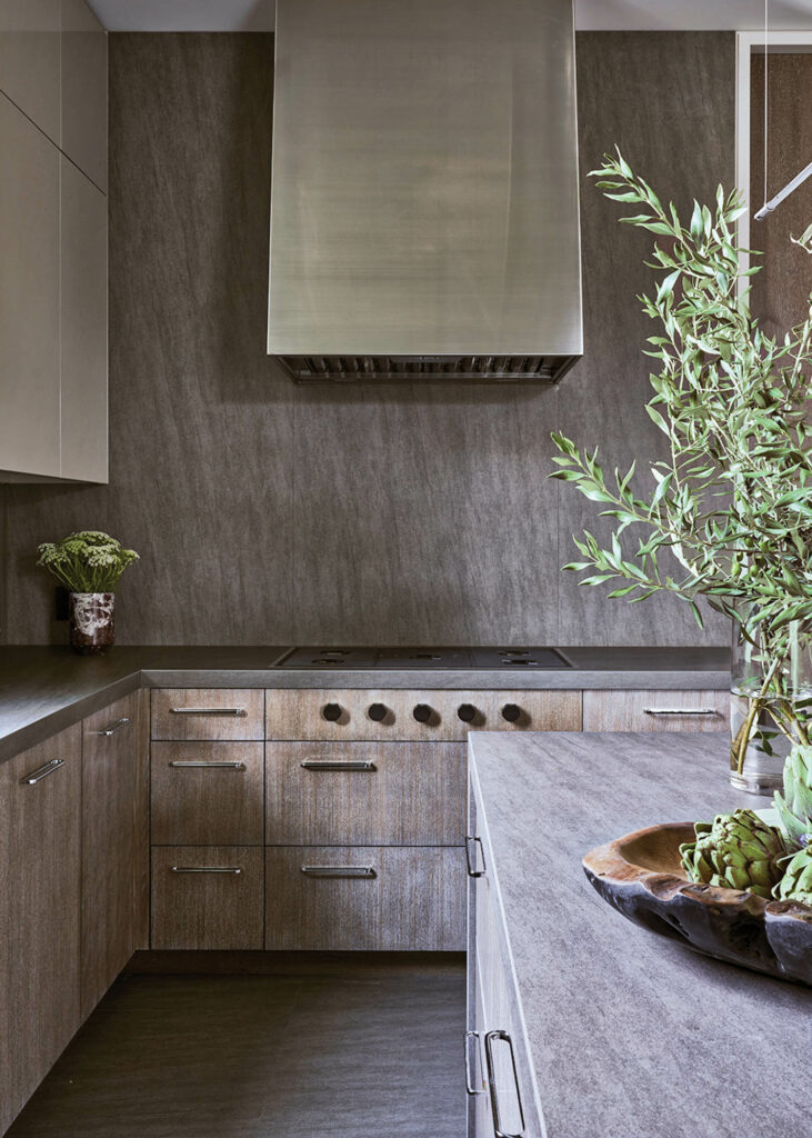 a kitchen with stone countertops, backsplash, and floor