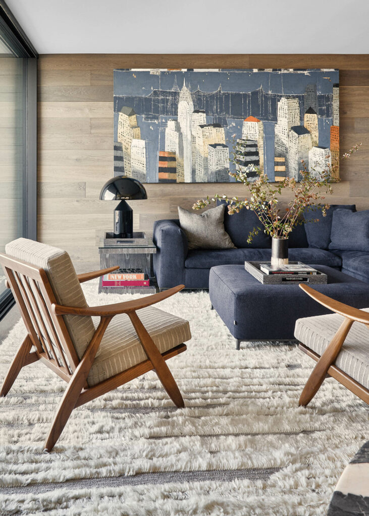 a textured rug beneath armchairs and a sofa in a penthouse