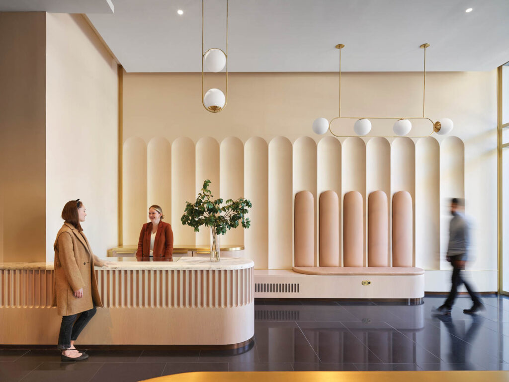 a white-oak reception desk in the lobby of 179 Lincoln Street