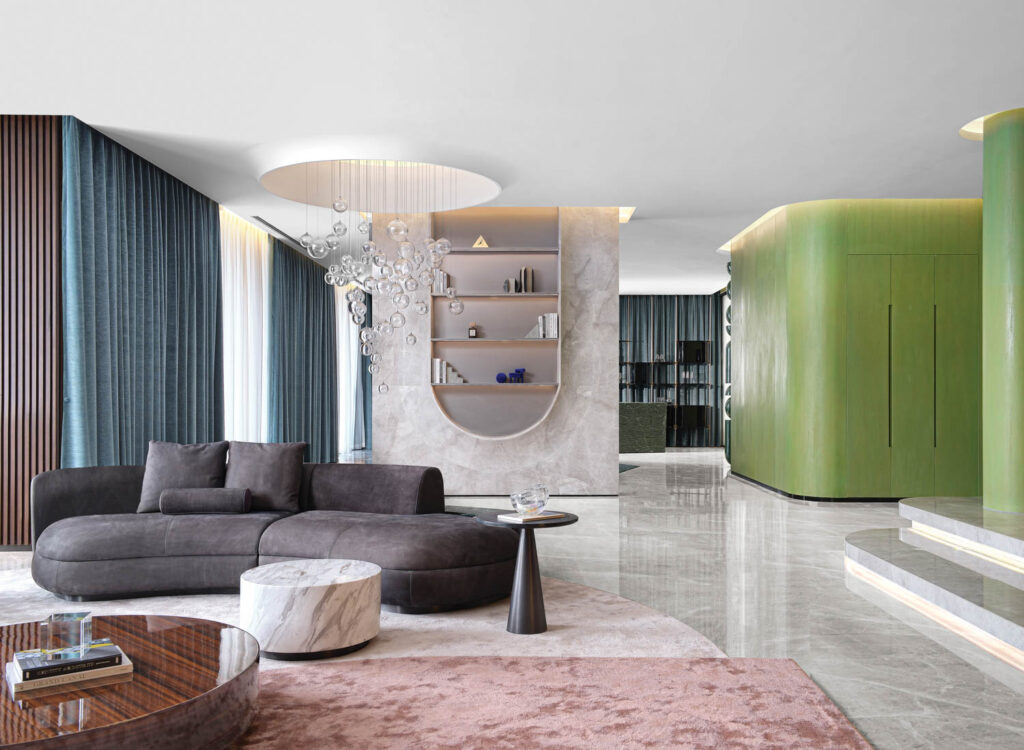 a custom pendant light hangs above a grey couch in an apartment living room