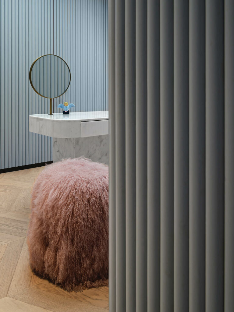 a marble vanity and a pink shag stool