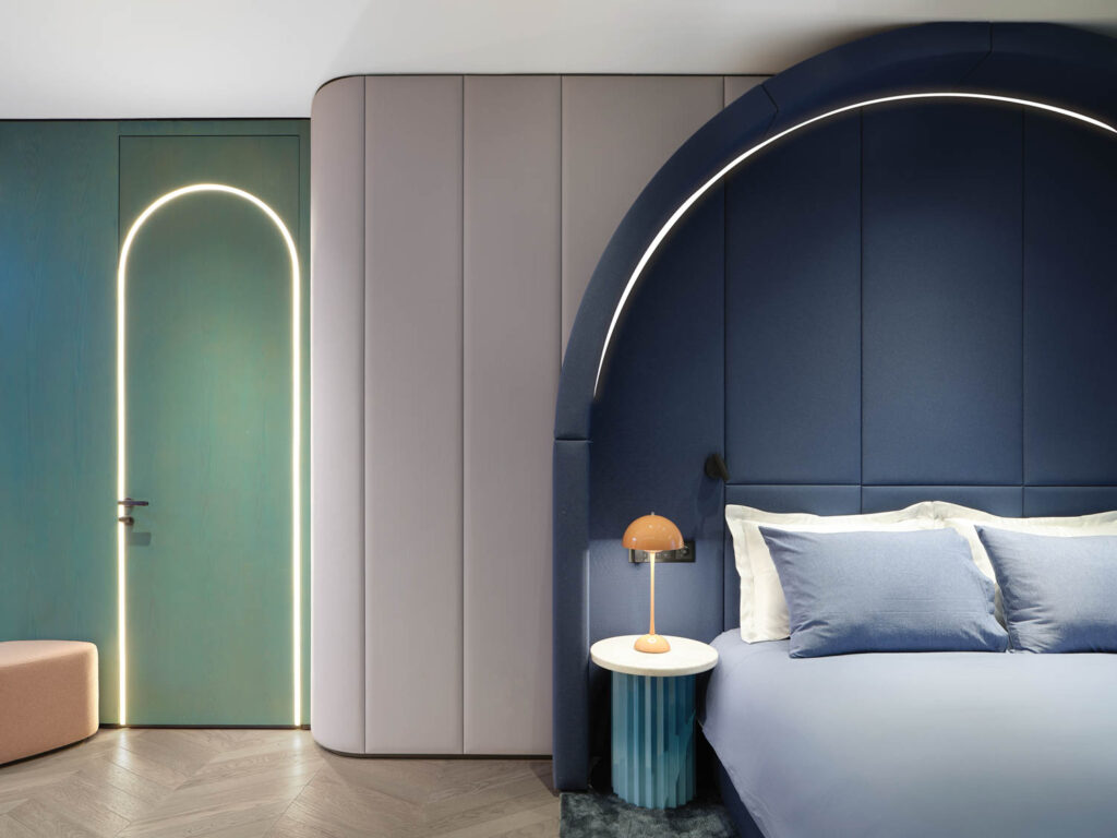 a door and headboard are decorated with LED arches in this bedroom