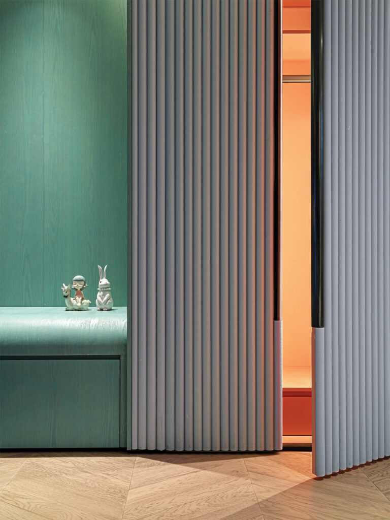 grey upholstered doors open to a bedroom closet