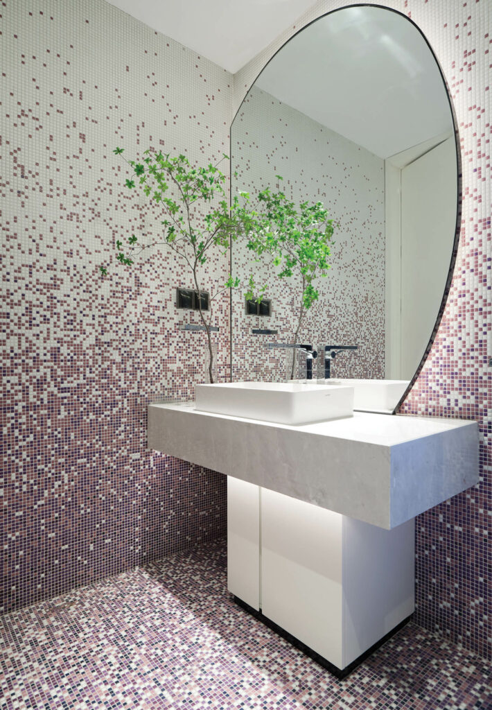 pink and white tiles mix to form a pixelated look in a guest bathroom