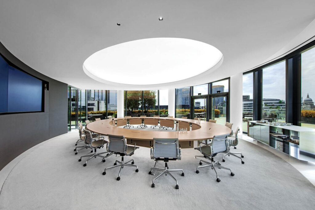 a meeting room with chairs surrounding a circular table