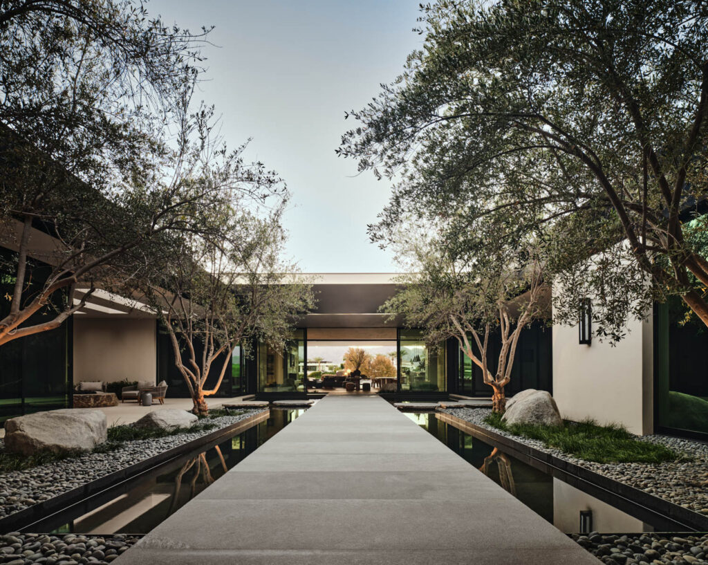 trees line the walkway to a Japanese-inspired home in California