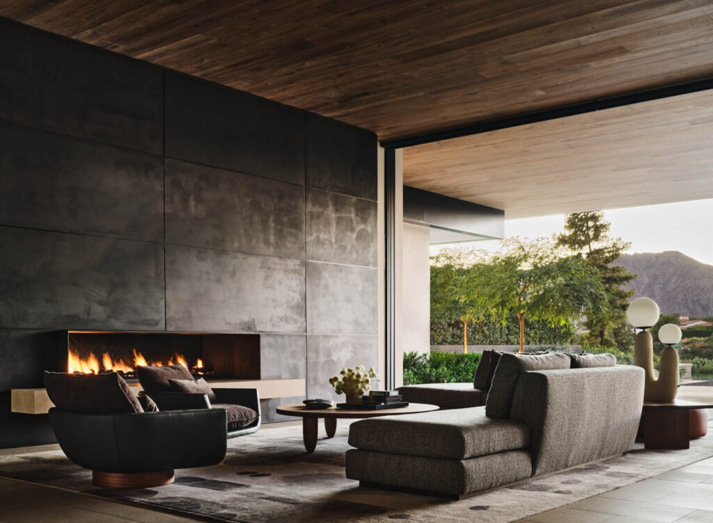 a living room decorated in neutrals with a long horizontal fireplace going