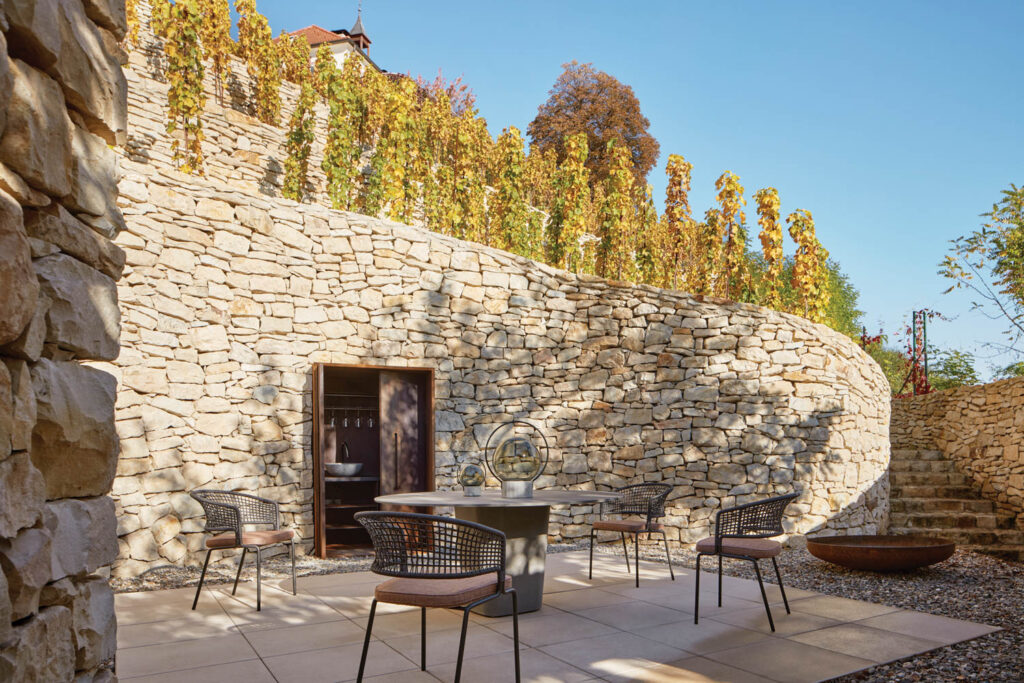 the patio of a winery with a stone retaining wall