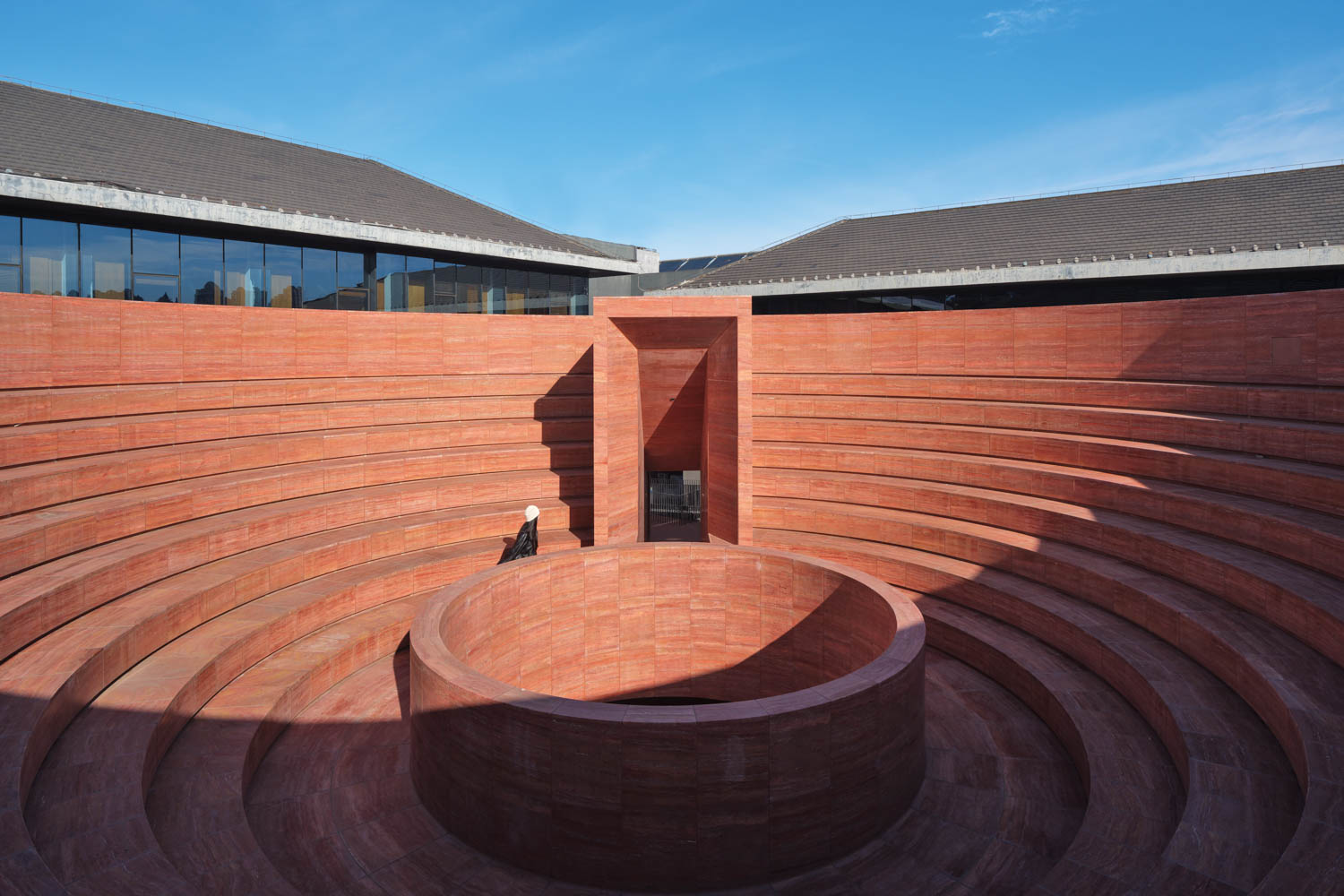 someone walks around the center of this circular structure at a Chinese museum