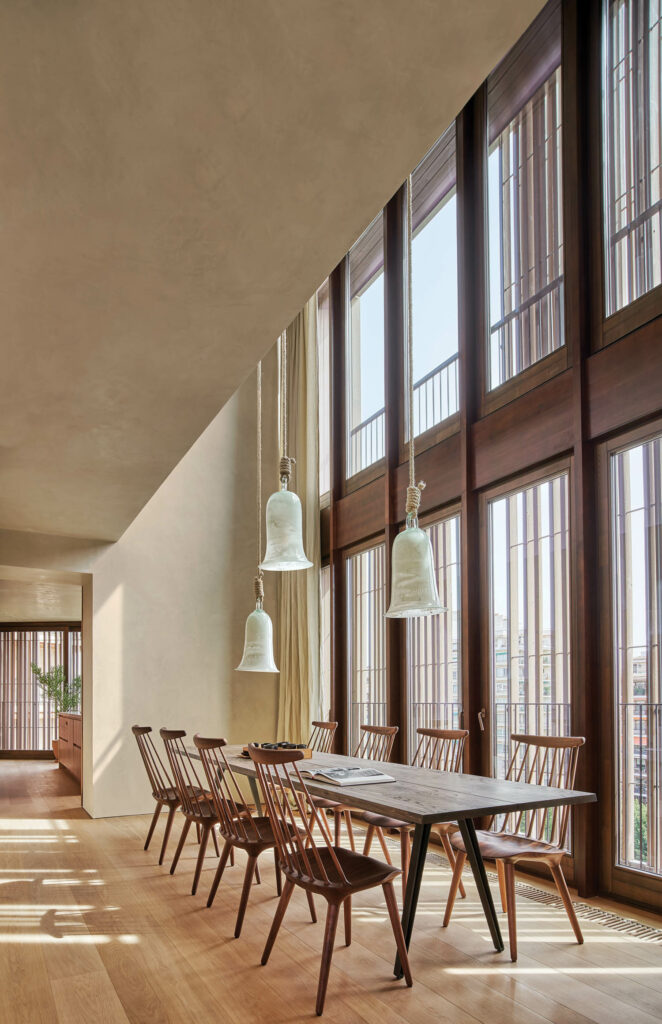 glass pendant fixtures hang above a dining table in a penthouse