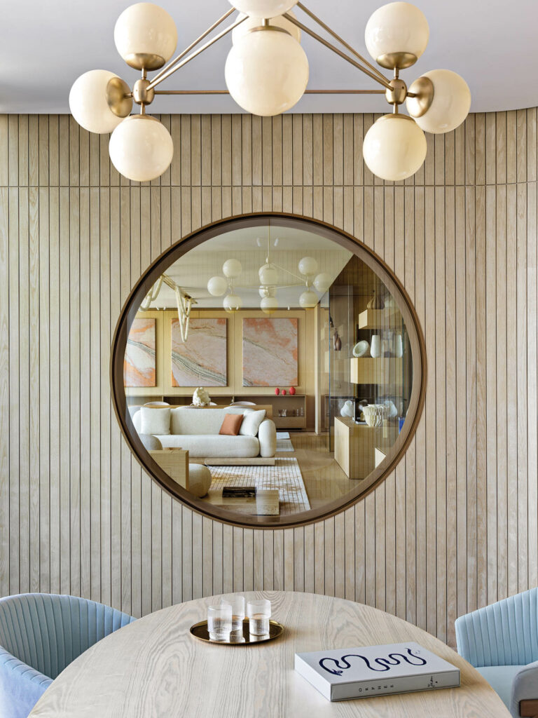 a porthole window connects a study with a living-dining area in this apartment