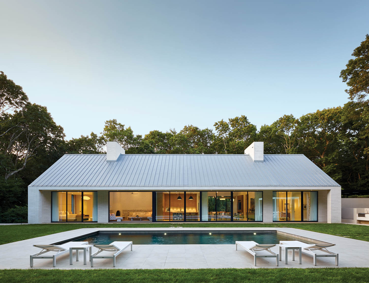 an in-ground pool surrounded by porcelain pavers at this home