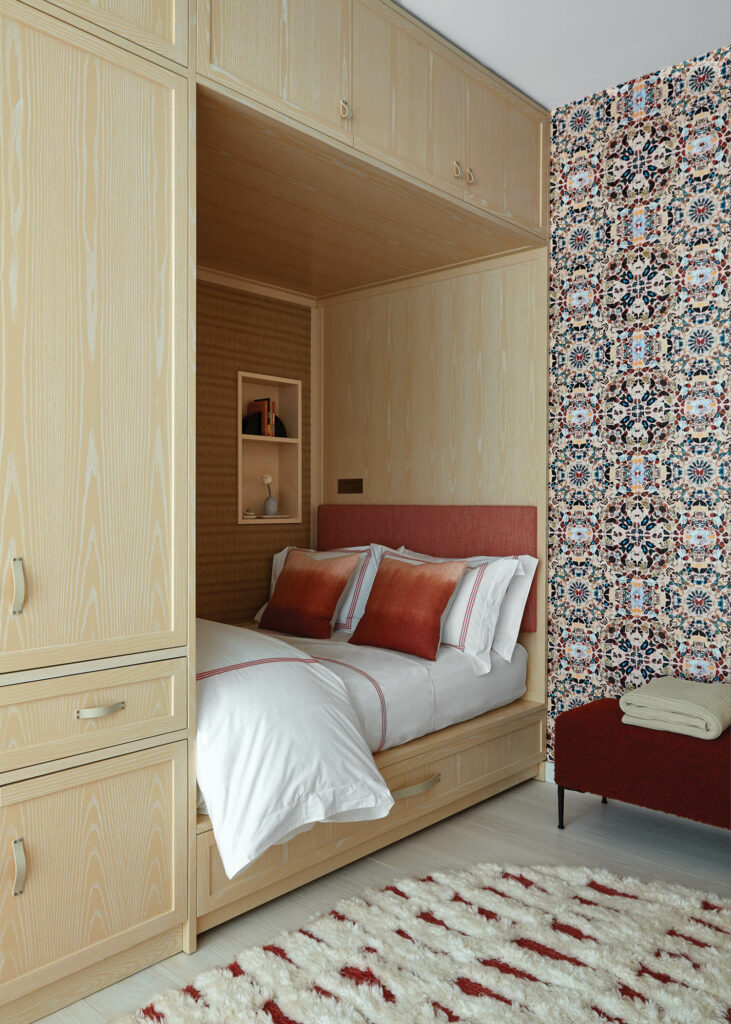 butterfly kaleidoscope wallpaper accents a wall next to a built-in bed in this girls bedroom