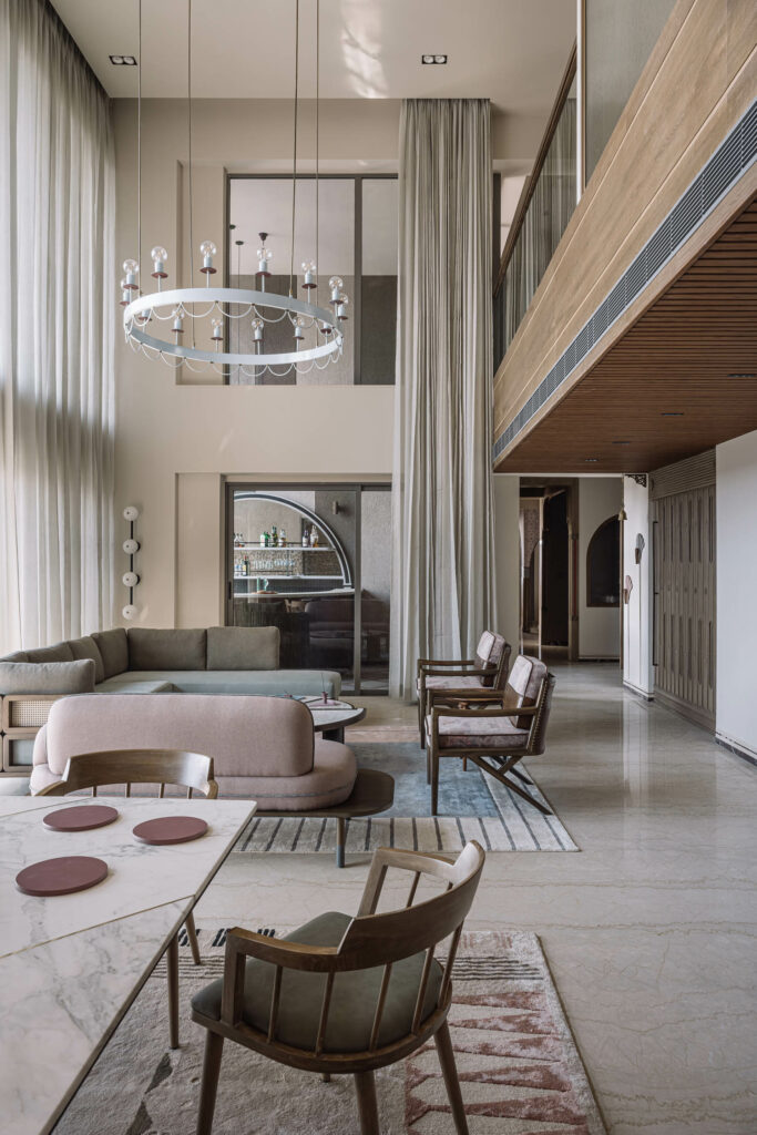 floor to ceiling windows covered by curtains in a neutrally decorated luxury apartment