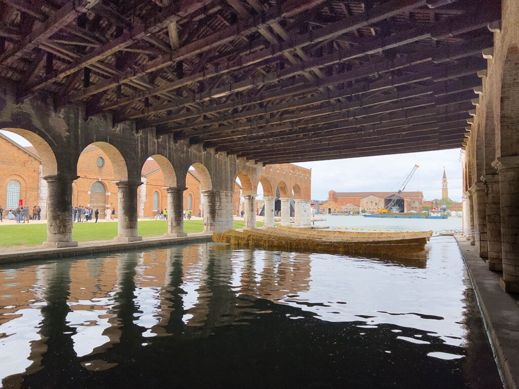 Time and Chance, an installation tapestry made from thousands of squares cut from plastic gallon containers, in a canal