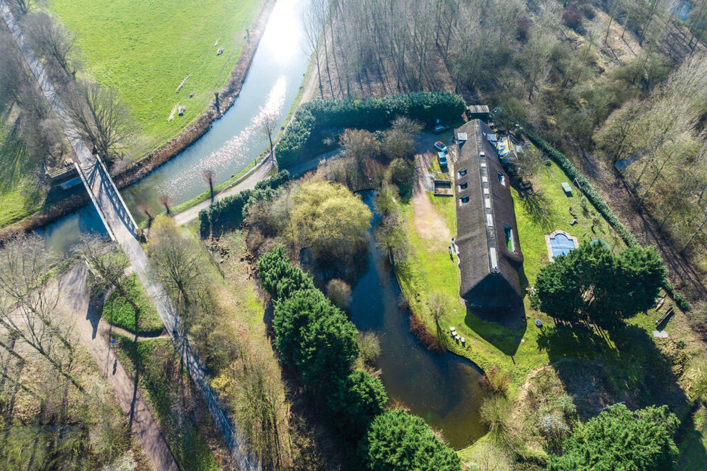 an aerial view of a pond and house in Belgium