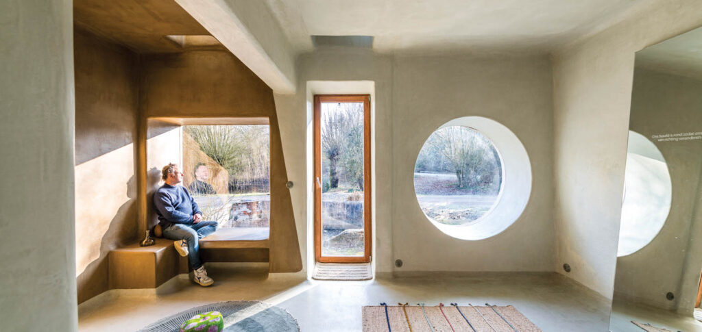 the main bathroom of a home with polished lime floors and windows in various shapes