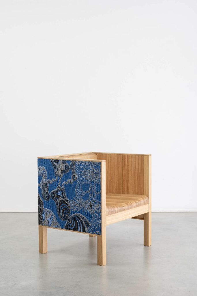 A wood chair with a blue ornate pattern on the shell