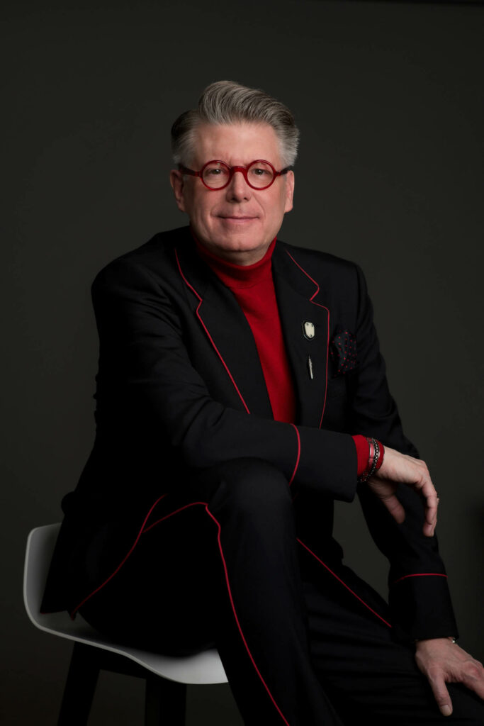 Ken Baker in a red shirt and black jacket