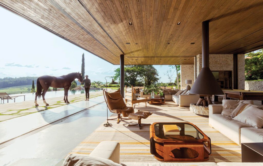 An open-air living room that looks out to a horse pasture