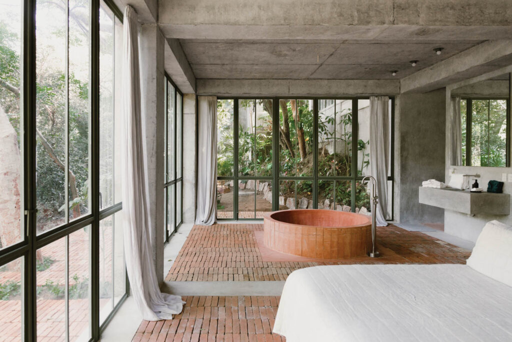 a soaking tub in the bedroom of a ground floor suite at Nico Sayulita