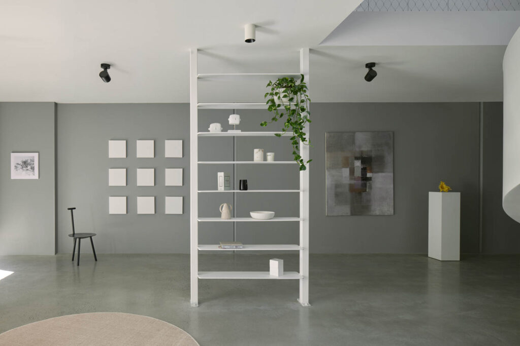 A white ladder shelf near a gray wall