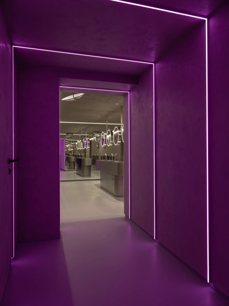 a purple hallway framed with LEDs leading to the bathroom