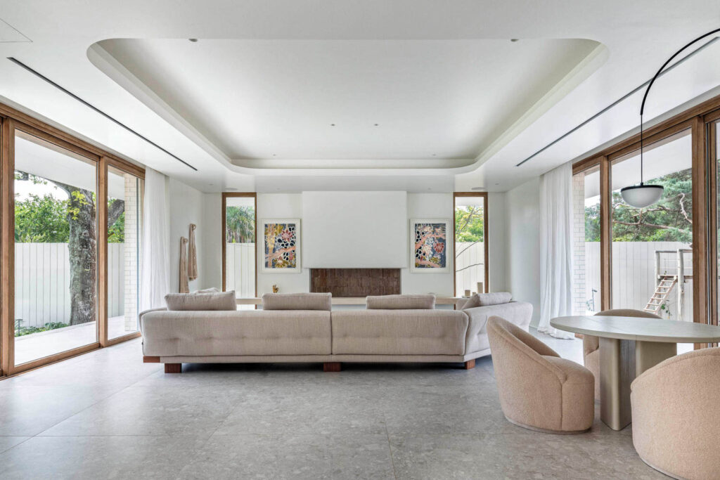 a living room with a long tan sofa and white walls