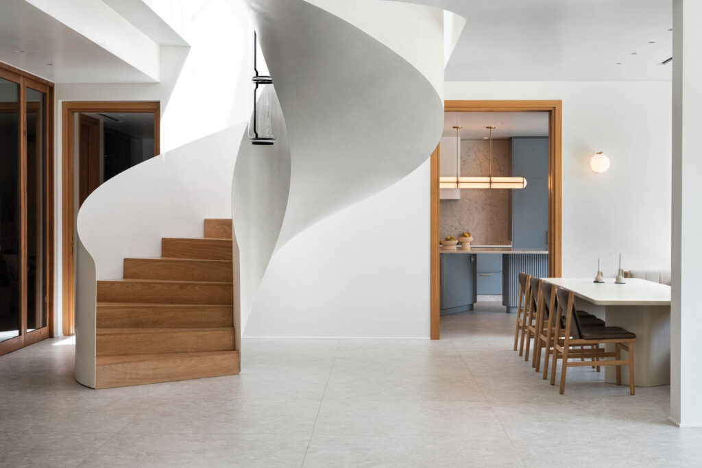 a dining area near a winding white staircase