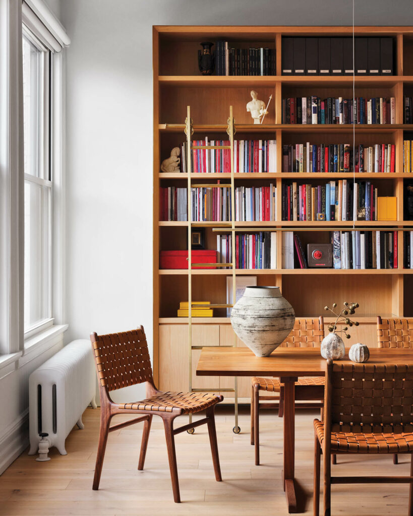 an oak bookshelf in a dining room with a wood table