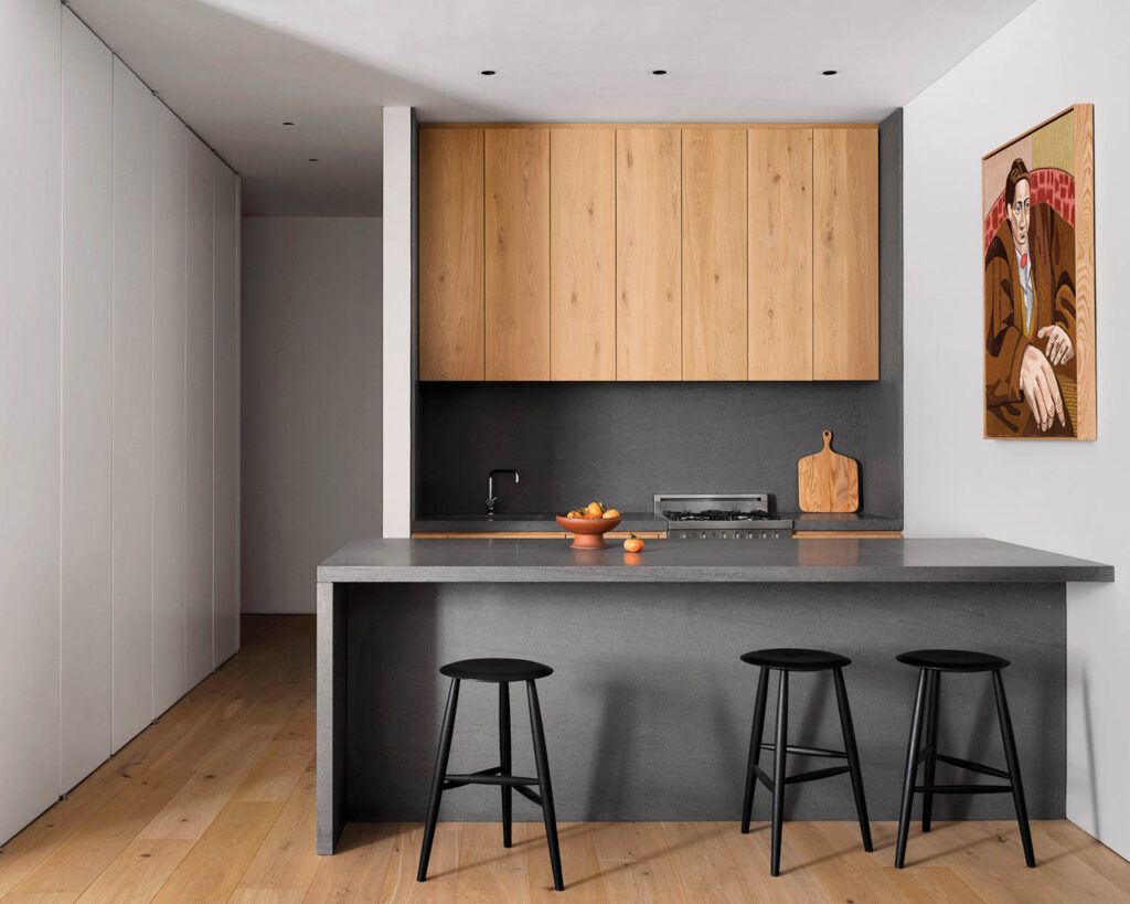 a gray kitchen island with oak cabinets and wood flooring