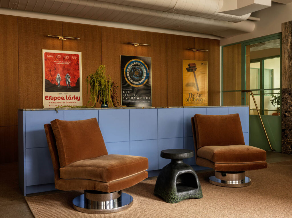 Two plush chairs near a blue wall