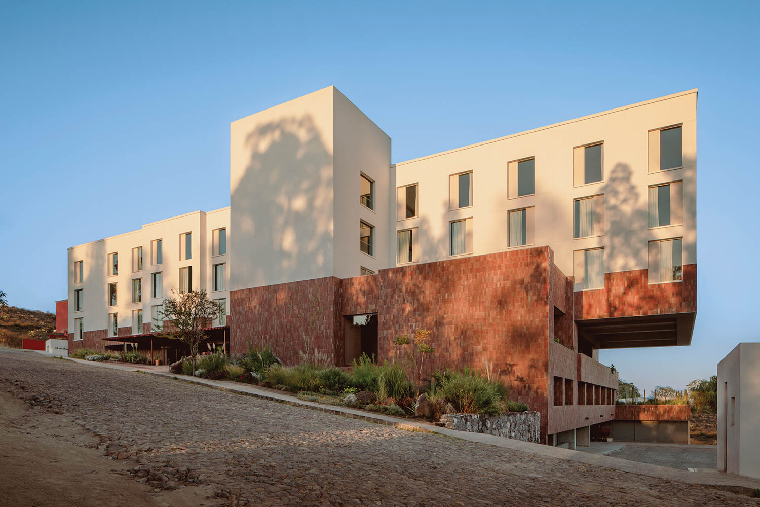 the exterior of a Hilton hotel in Mexico, with the architecture inspired by the tones of the mountainous terrain