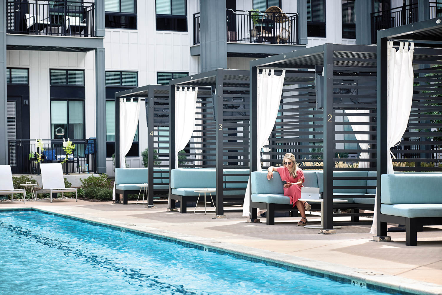 a pool with cabanas surrounding it