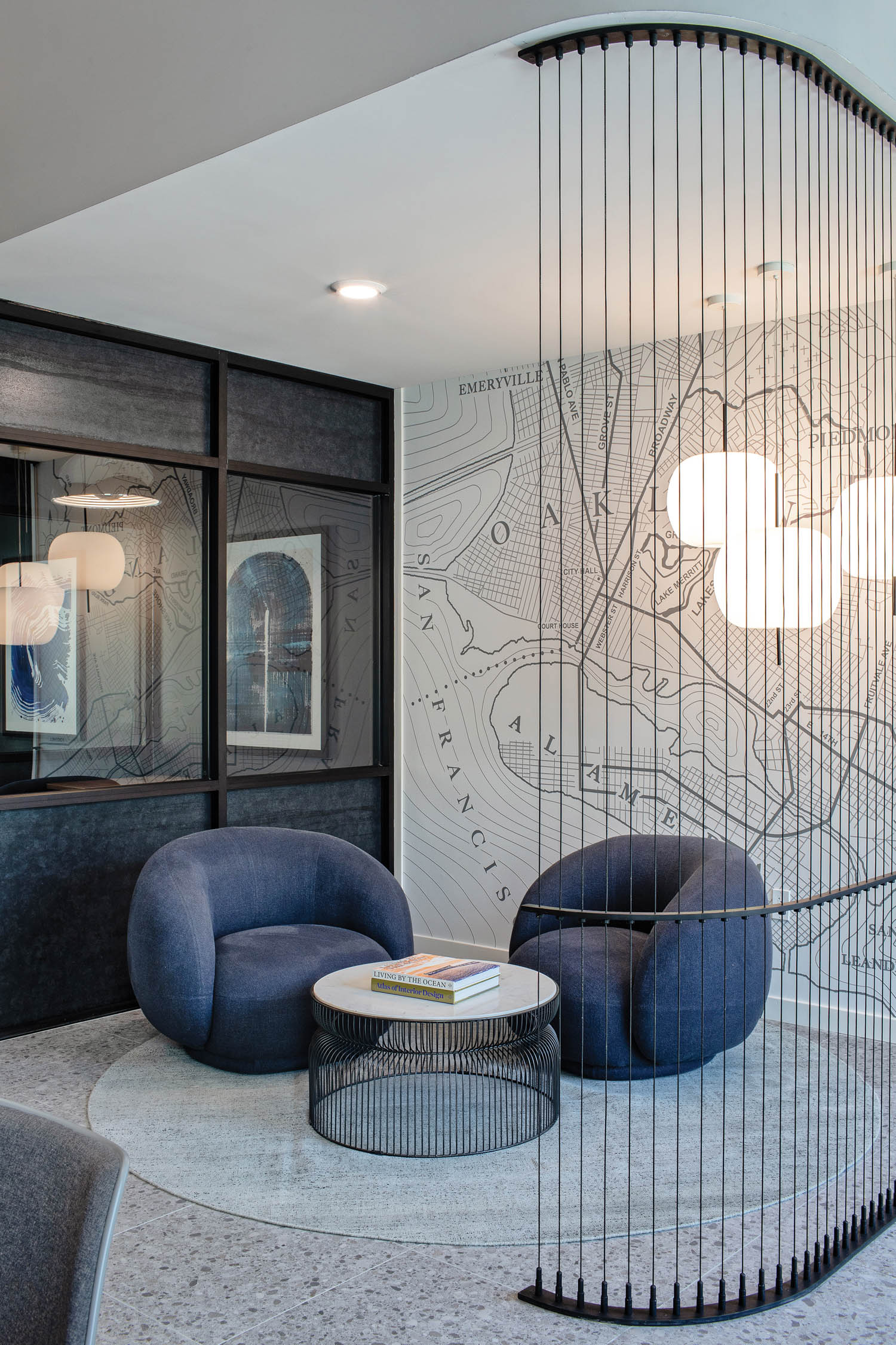 two curved and plush gray armchairs in a room corner