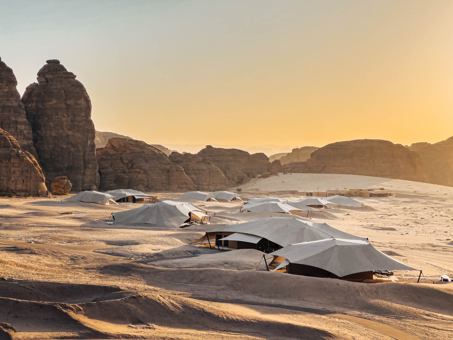 the sun sets over the Banyan Tree AlUla