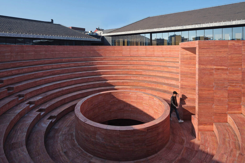 a red cylinder base in a bowl-shaped ampitheater