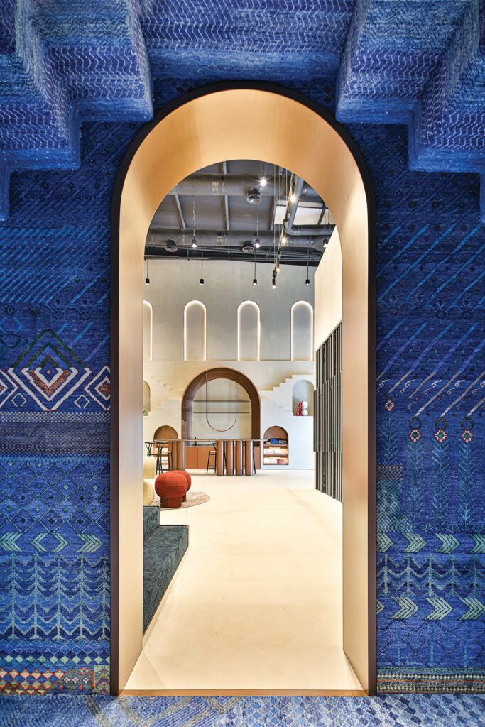 a curved doorway surrounded by blue walls inside Jaipur Rugs