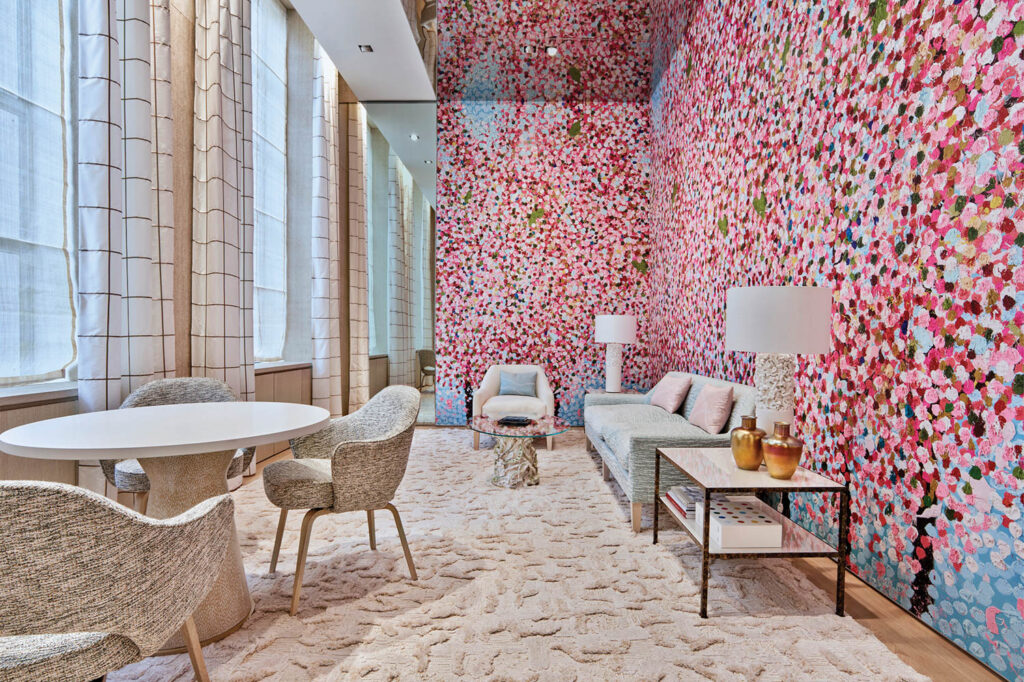 a room with pink floral wallpaper and plush furnishings in Tiffany & Co