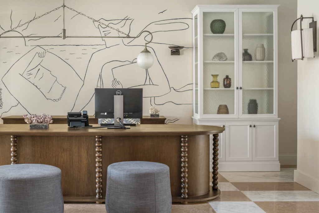 reception area with solid wood desk and sketches on walls