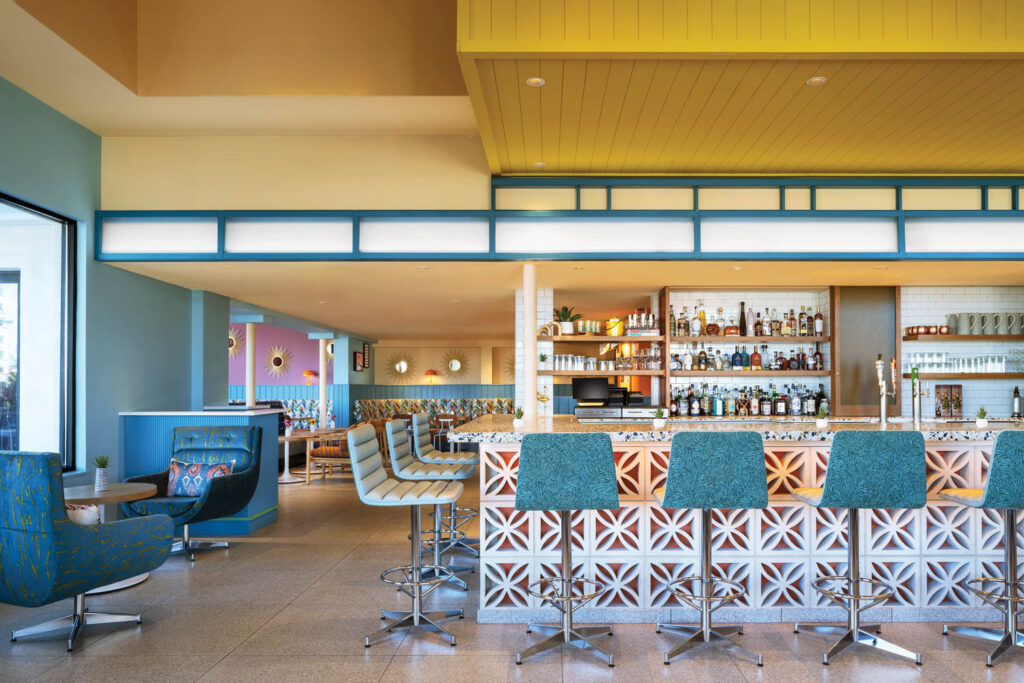 retro-style dining area of The Wayback with patterned counters and blue bar stools