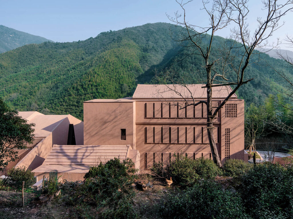 exterior facade of the resort with the green mountain scenery in background